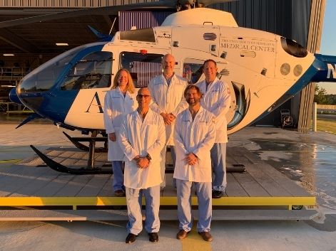 Trauma faculty stand in front of AirCare helicopter.